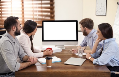 Photo of Group of colleagues using video chat on computer in office. Space for text