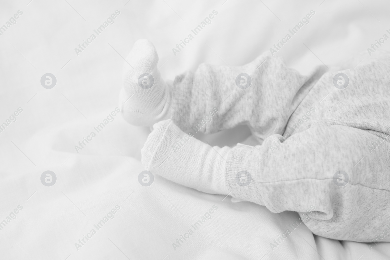 Photo of Newborn baby lying on white blanket, closeup