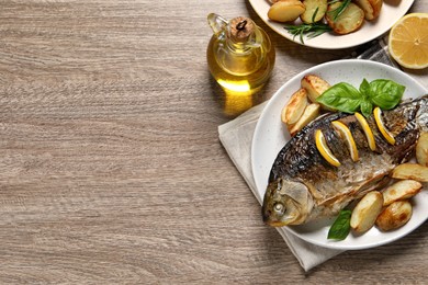 Tasty homemade roasted crucian carp served on wooden table, flat lay and space for text. River fish