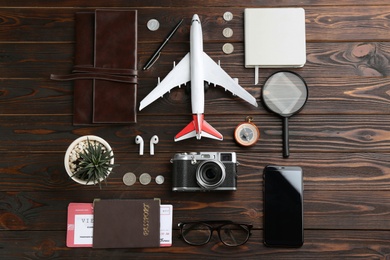 Flat lay composition with toy airplane and travel items on wooden background