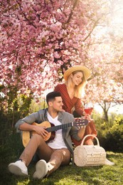 Photo of Lovely couple having picnic in park on sunny spring day