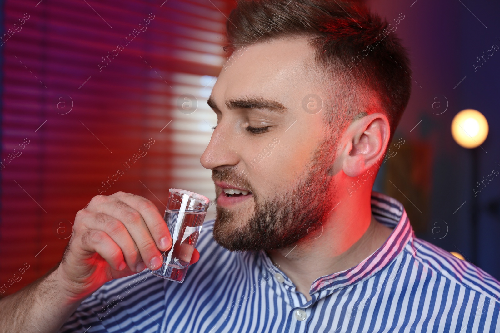 Photo of Young man with Mexican Tequila shot in bar