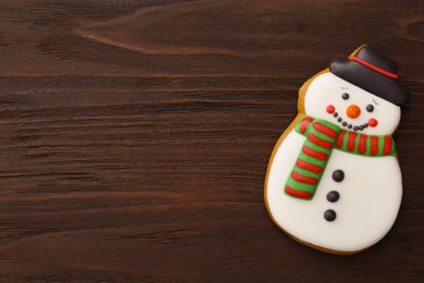 Photo of Snowman shaped Christmas cookie on wooden table, top view. Space for text