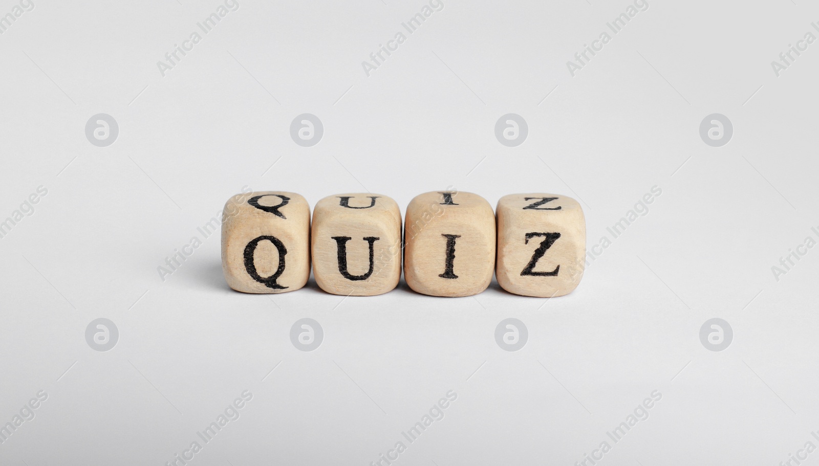 Photo of Wooden cubes with word Quiz on white background