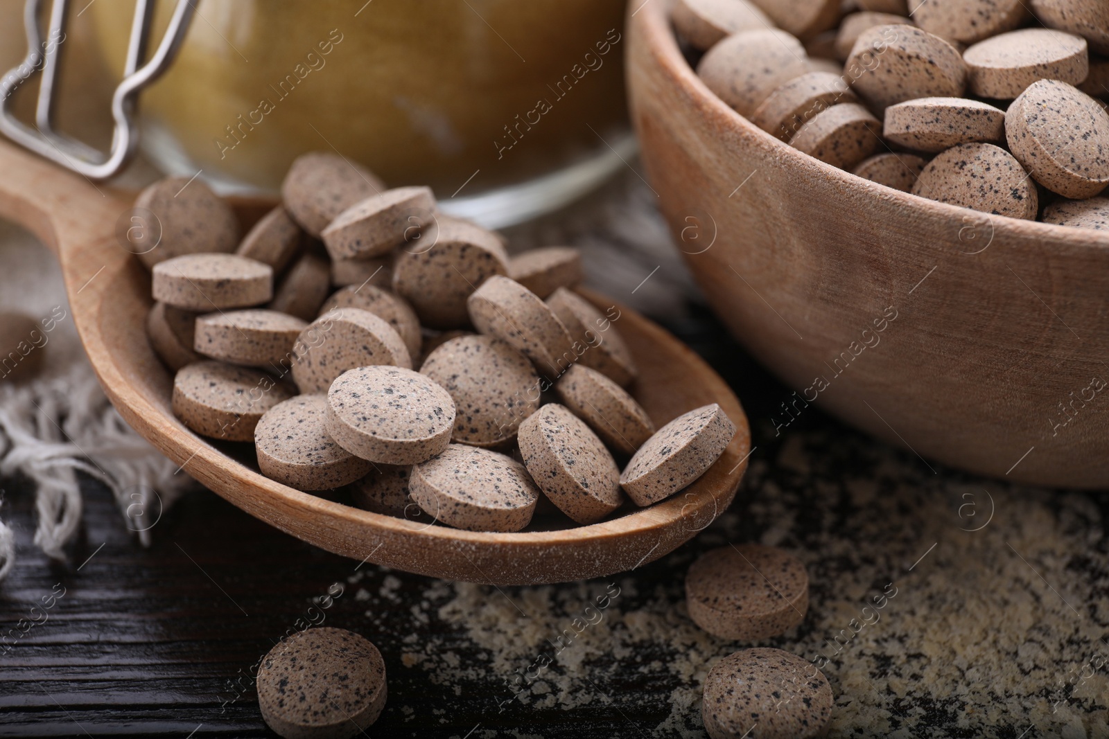 Photo of Brewer`s yeast tablets on wooden table, closeup