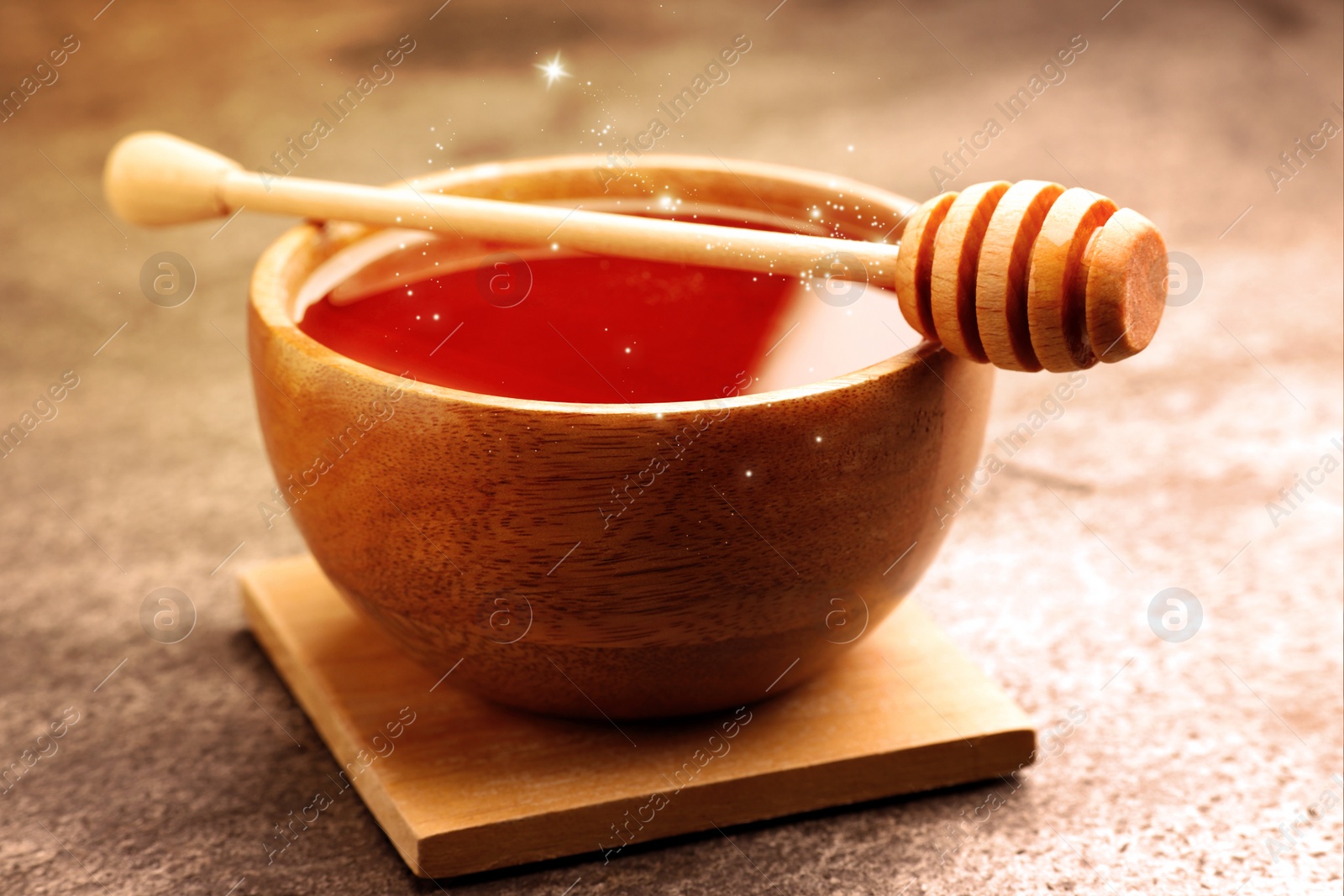 Image of Natural honey in wooden bowl and dipper on table under sunlight, closeup