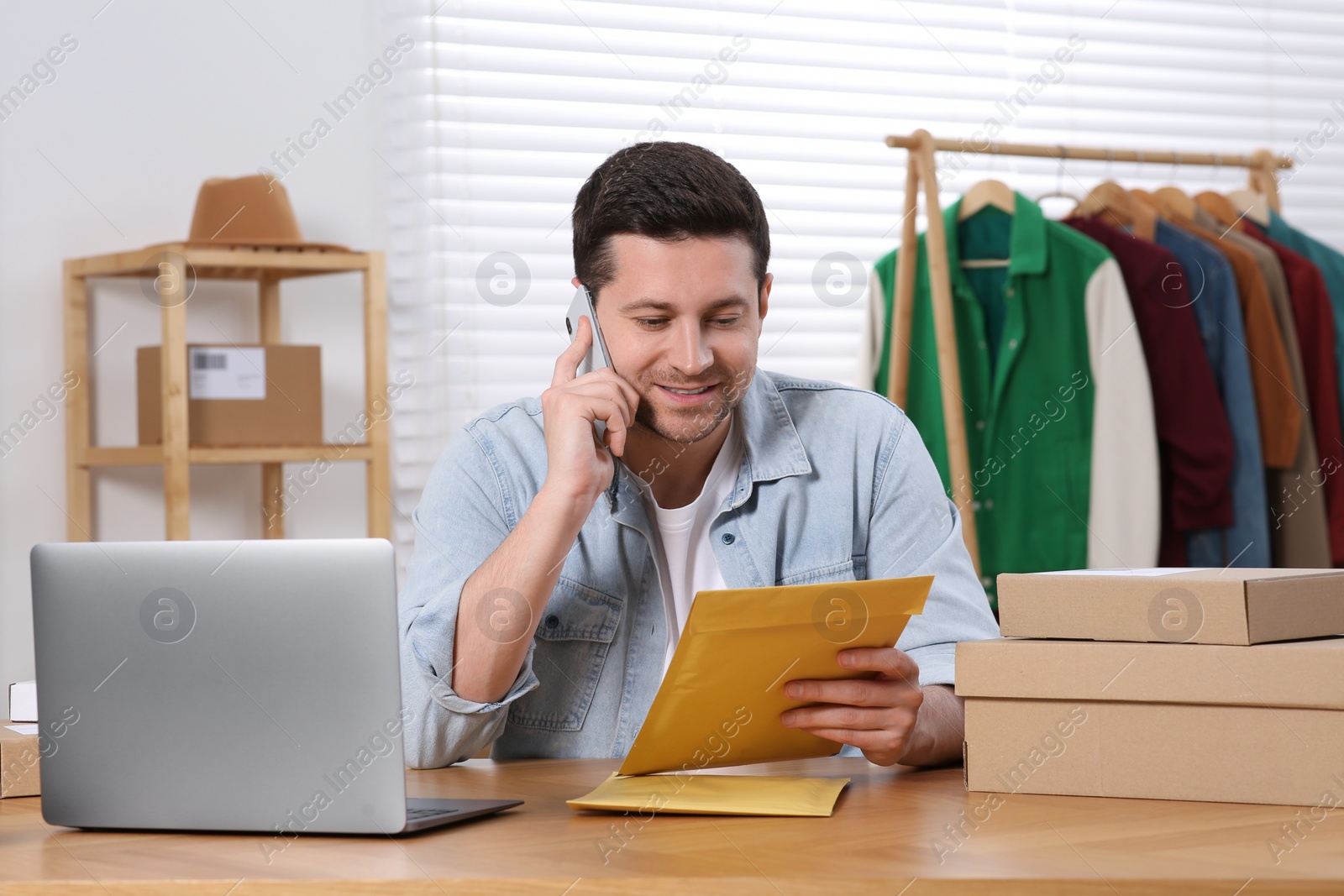 Photo of Seller talking on phone while working in office. Online store