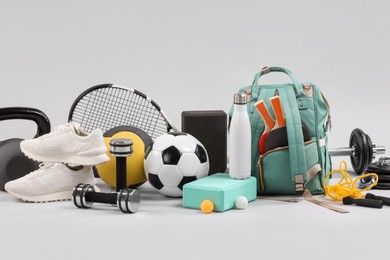 Photo of Many different sports equipment on light grey background