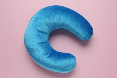 Photo of Light blue travel pillow on pink background, top view