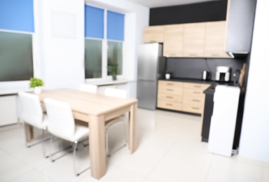 Blurred view of cozy modern kitchen interior with new furniture and appliances