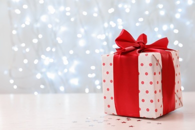 Photo of Christmas gift on table against blurred background