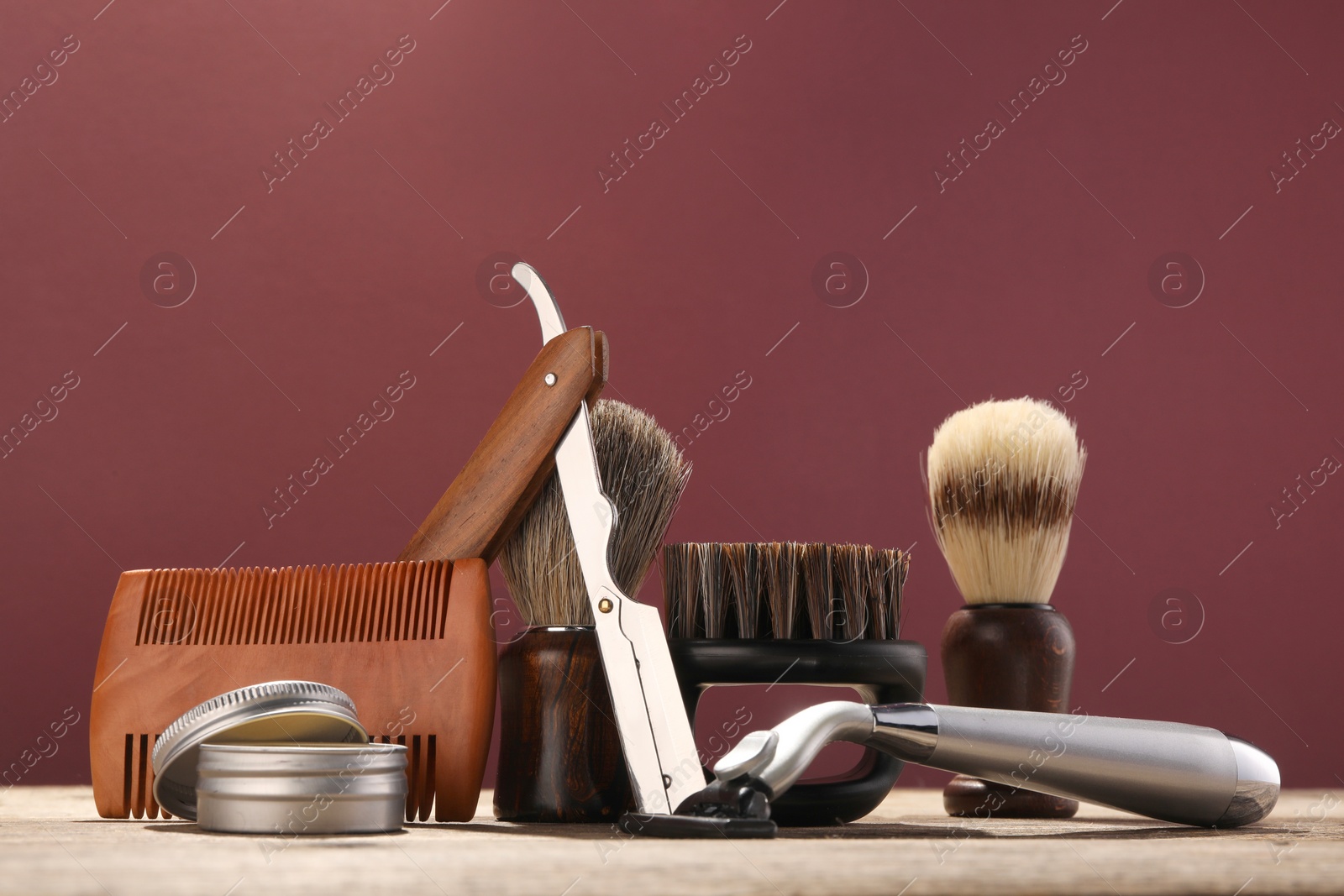 Photo of Moustache and beard styling tools on wooden table