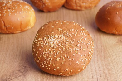 Photo of Fresh buns with sesame seeds on wooden table