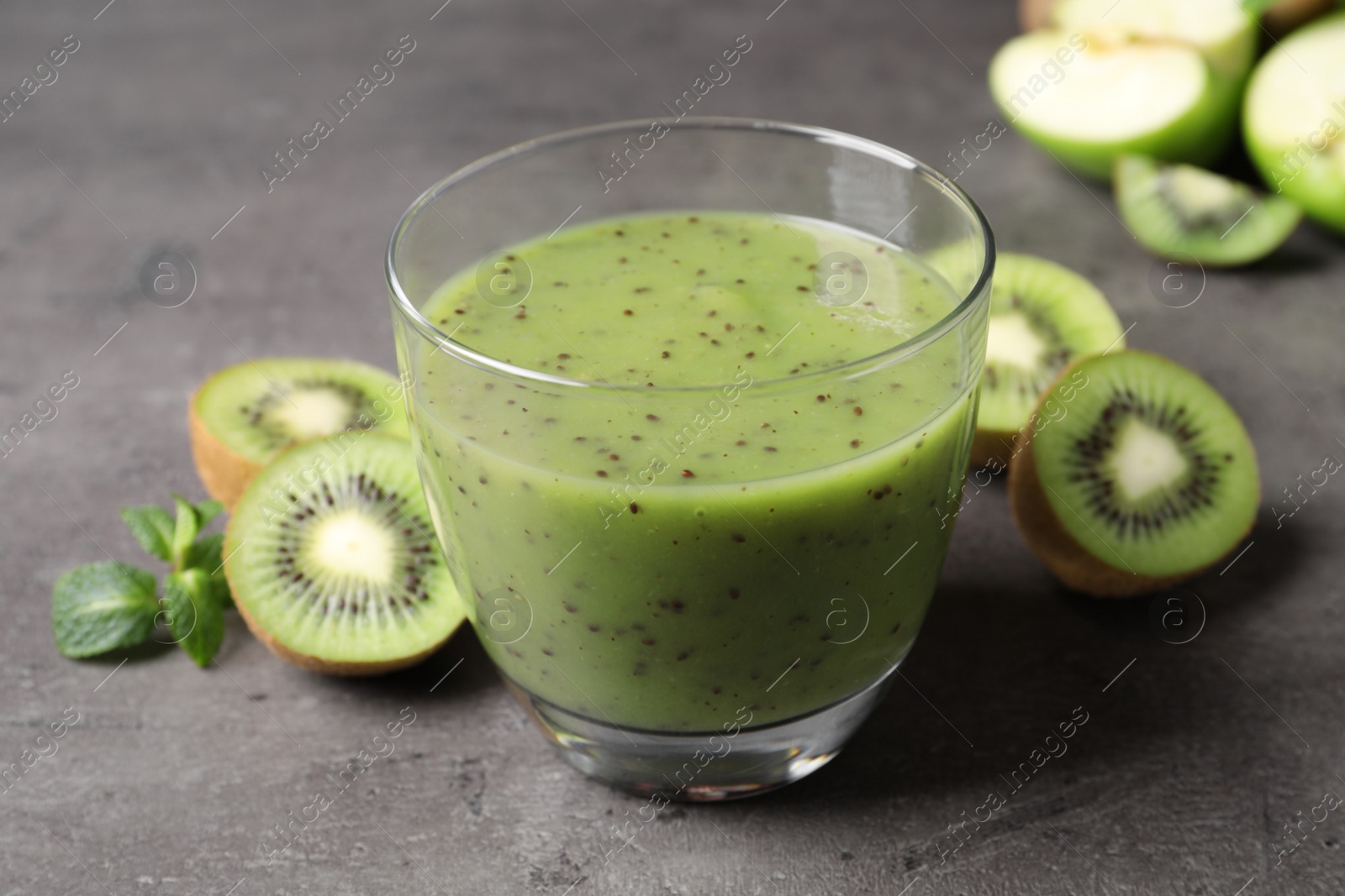 Photo of Delicious kiwi smoothie and fresh fruits on grey table