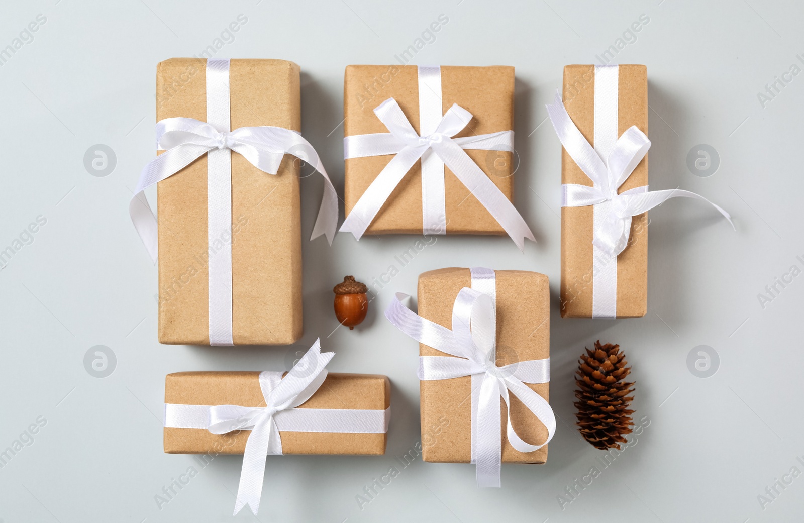 Photo of Christmas gift boxes with white bows on grey background, flat lay