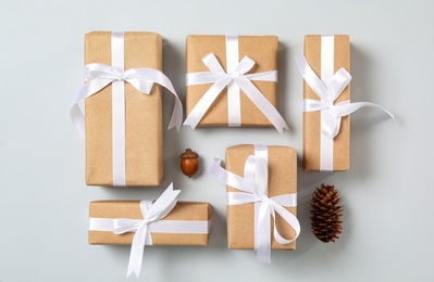 Christmas gift boxes with white bows on grey background, flat lay