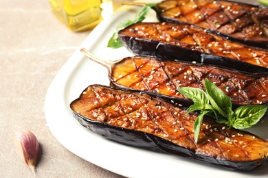 Photo of Plate with fried eggplant slices on table, closeup