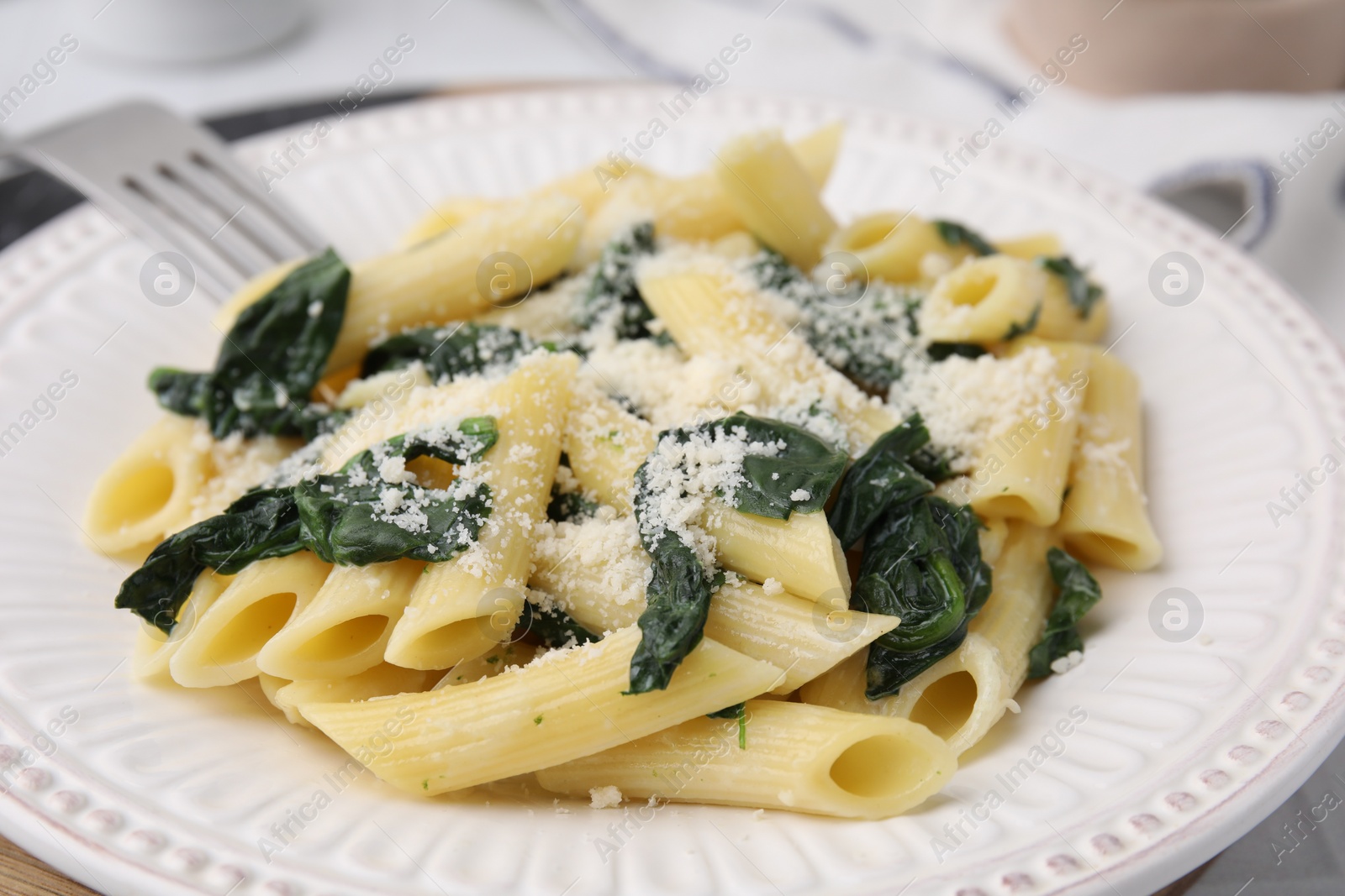 Photo of Tasty pasta with spinach and cheese on white table, closeup