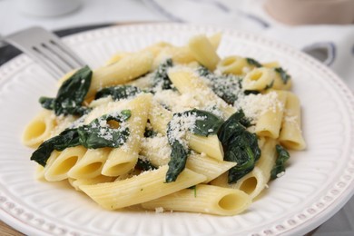 Tasty pasta with spinach and cheese on white table, closeup