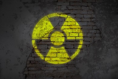 Image of Radioactive sign on old brick wall. Hazard symbol