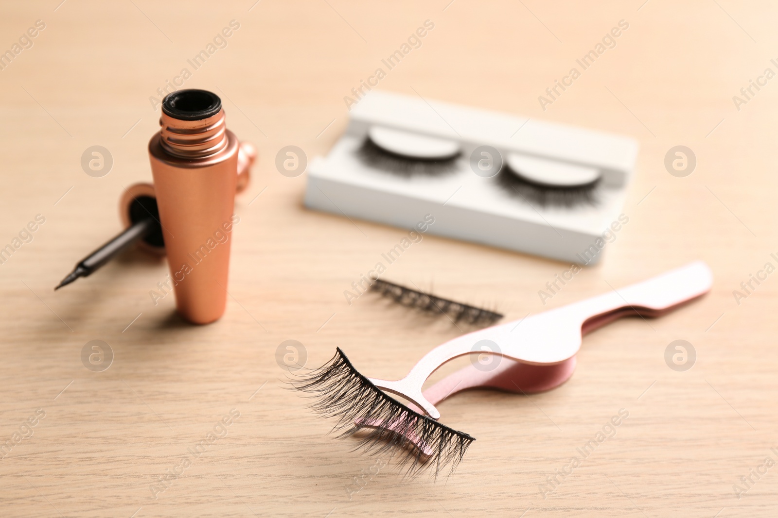 Photo of Magnetic eyelashes and accessories on wooden table