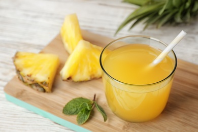 Photo of Glass with delicious pineapple juice on table