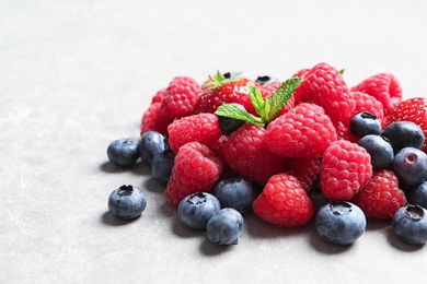 Photo of Raspberries, strawberries and blueberries on table