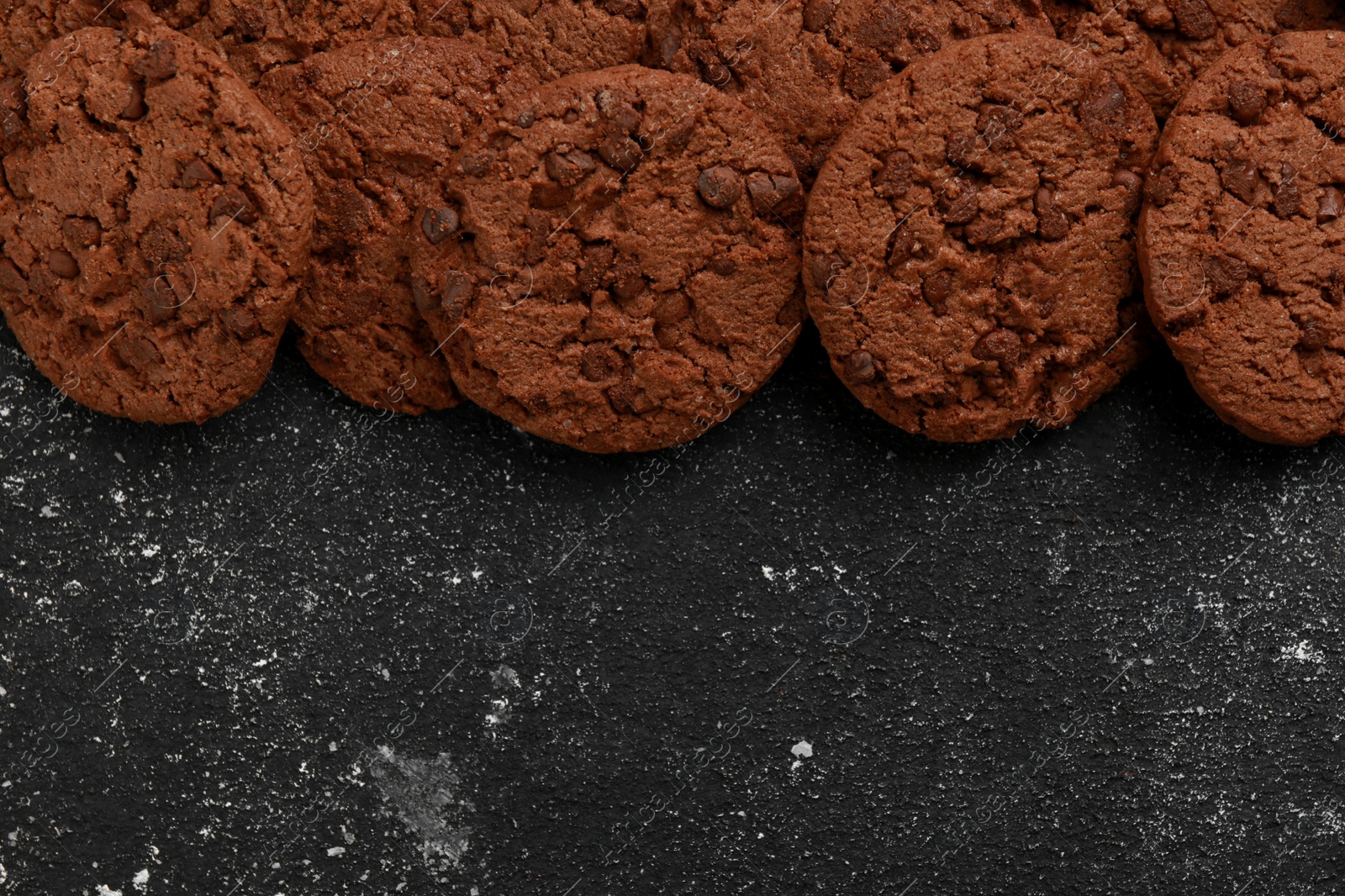 Photo of Tasty chocolate cookies on grey textured table, flat lay. Space for text