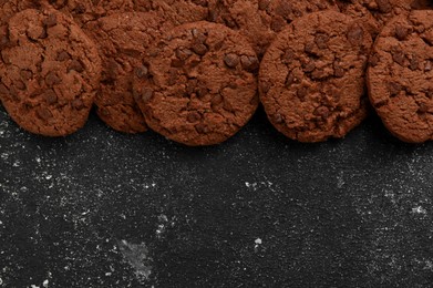 Tasty chocolate cookies on grey textured table, flat lay. Space for text