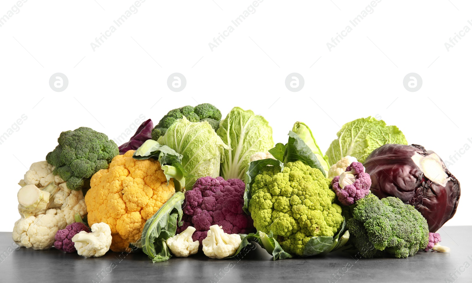 Photo of Different fresh cabbages on table against white background. Healthy food