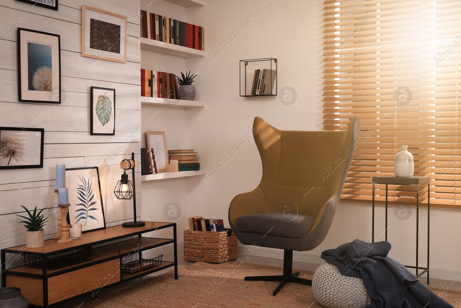 Photo of Cozy home library interior with comfortable armchair near window and collection of different books on shelves