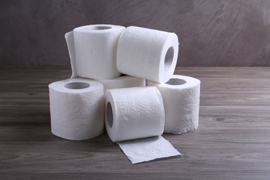 Photo of Soft toilet paper rolls on wooden table