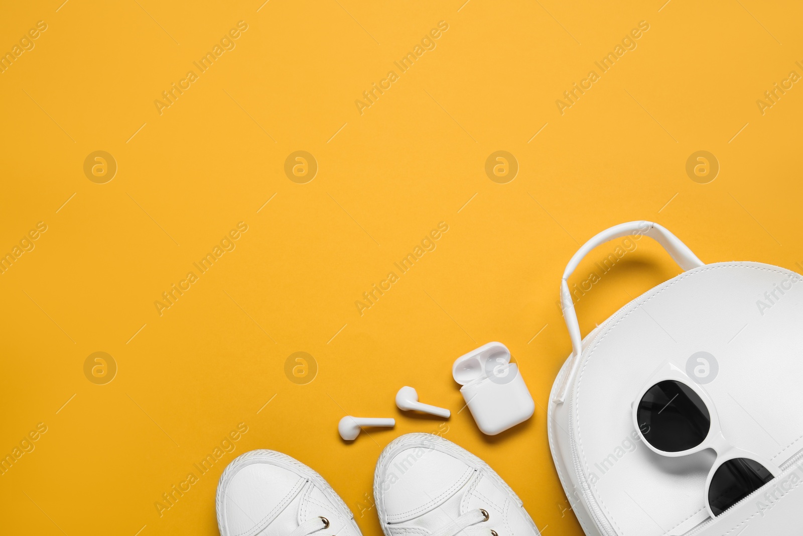 Photo of Flat lay composition with stylish backpack on yellow background, space for text