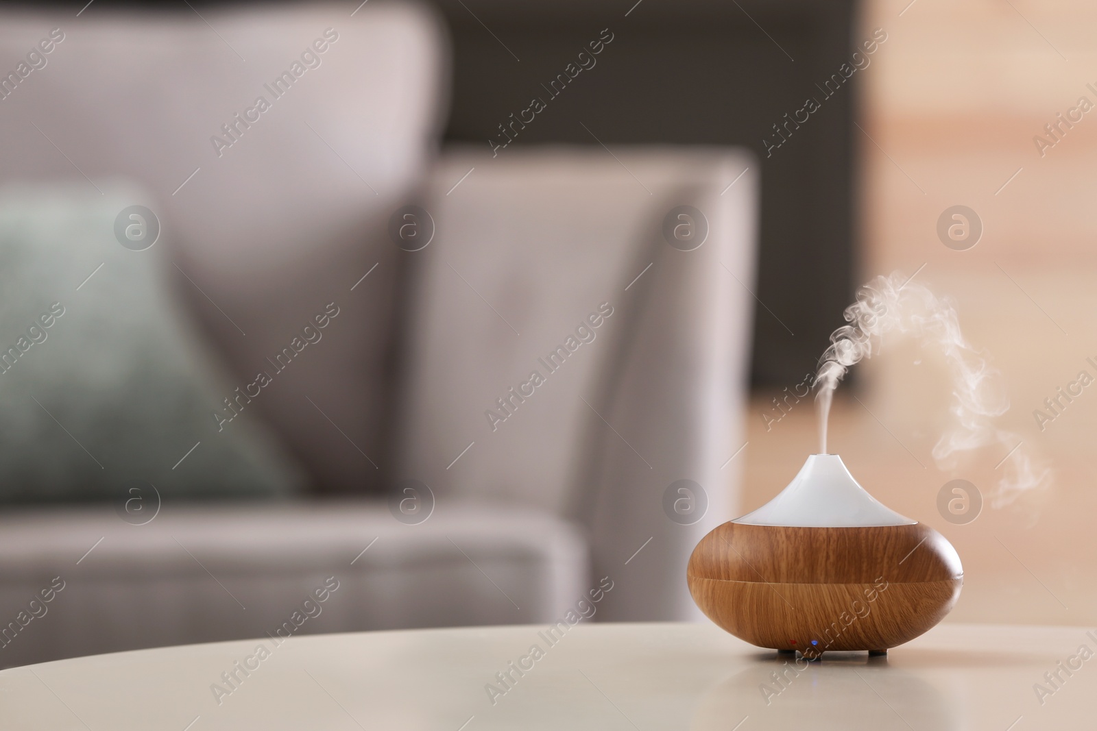 Photo of Aroma oil diffuser lamp on table against blurred background