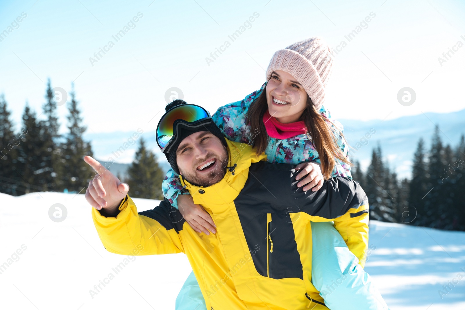 Photo of Happy couple spending time on snowy hill in mountains. Winter vacation