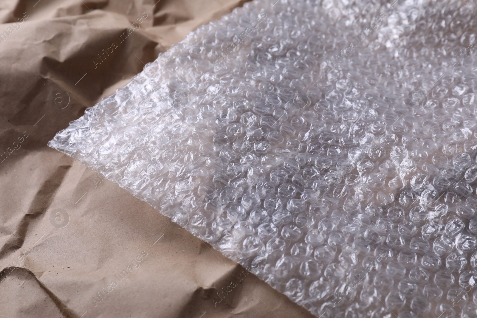 Photo of Transparent bubble wrap on kraft paper, closeup