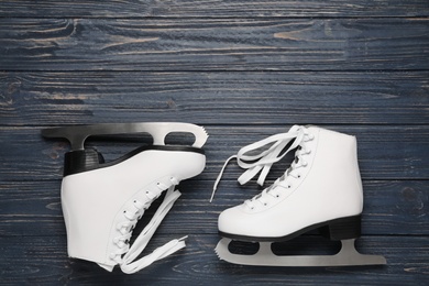 Photo of Pair of skates on dark blue wooden background, flat lay
