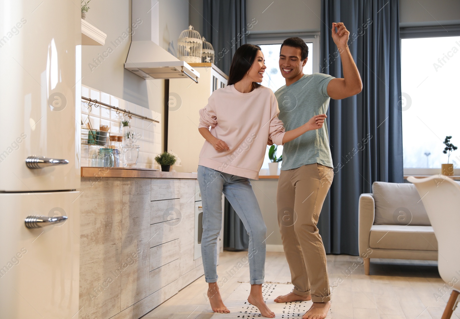 Photo of Lovely young interracial couple dancing at home