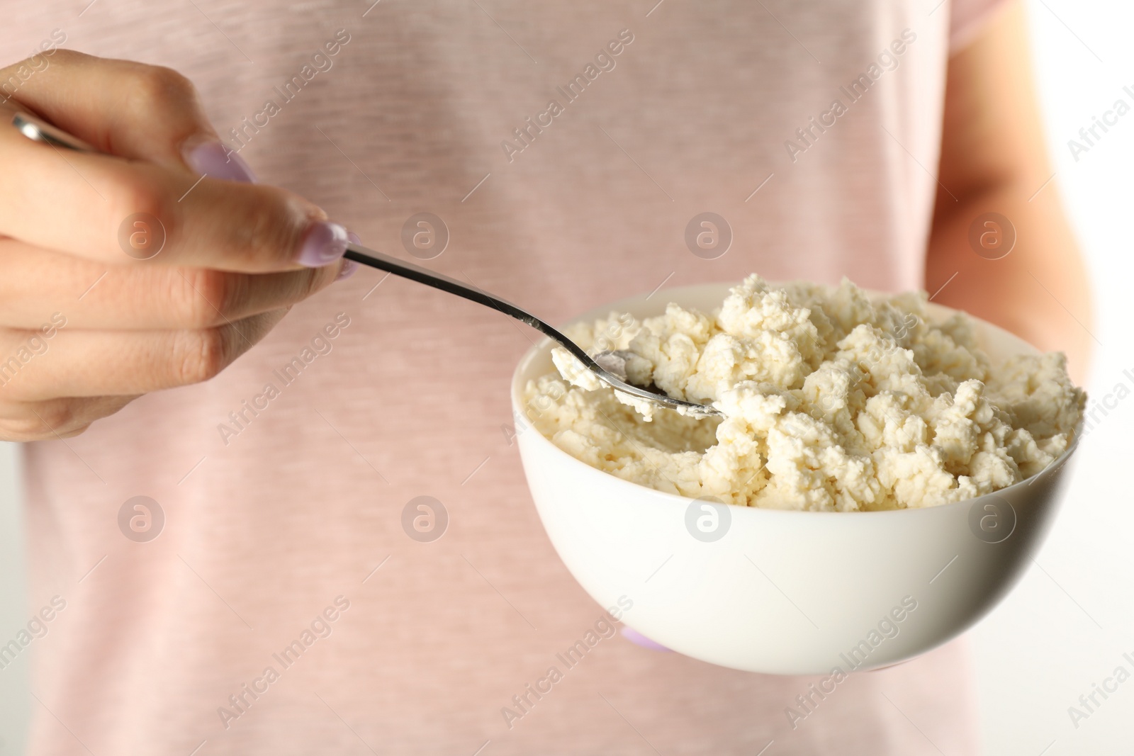 Photo of Woman with delicious fresh cottage cheese on white background, closeup