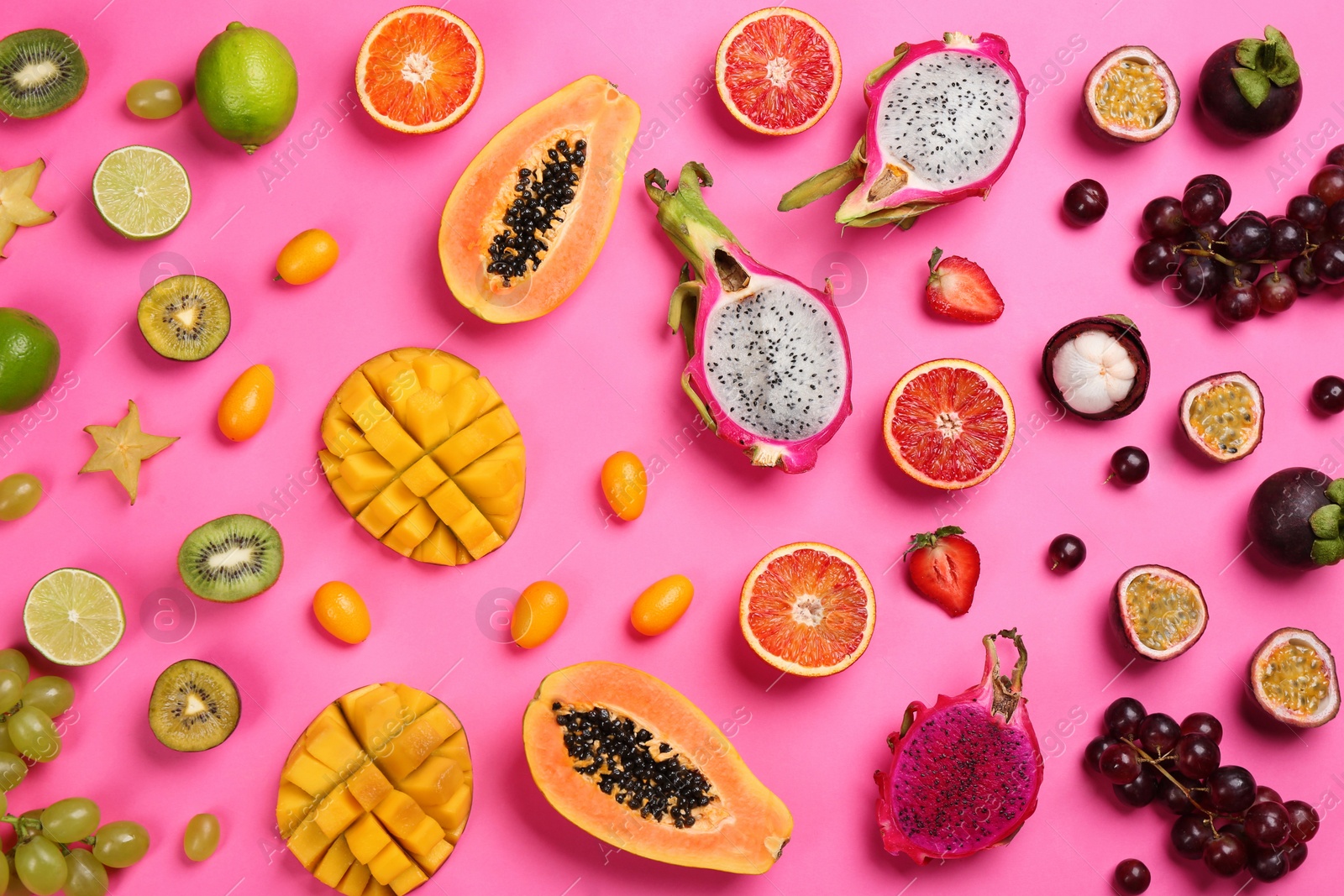 Photo of Many different delicious exotic fruits on pink background, flat lay