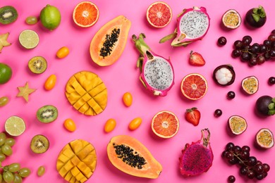 Many different delicious exotic fruits on pink background, flat lay