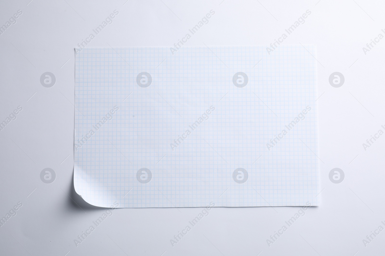 Photo of Checkered sheet of paper on white background, top view