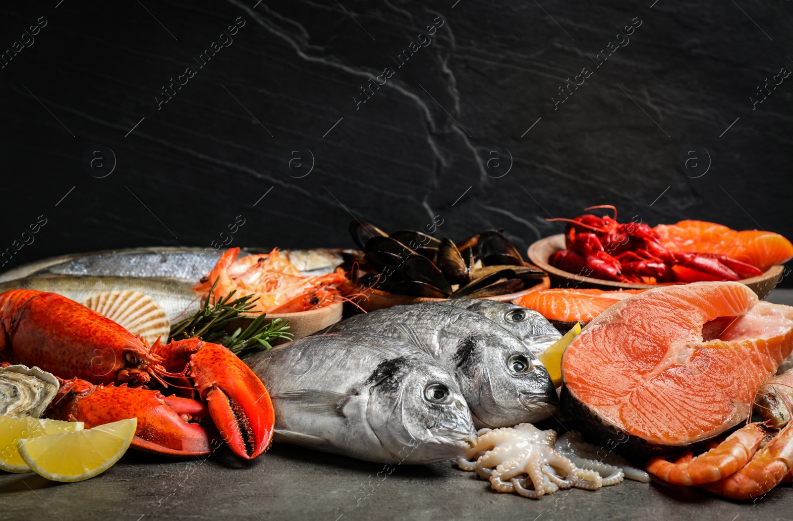 Photo of Fresh fish and different seafood on grey table