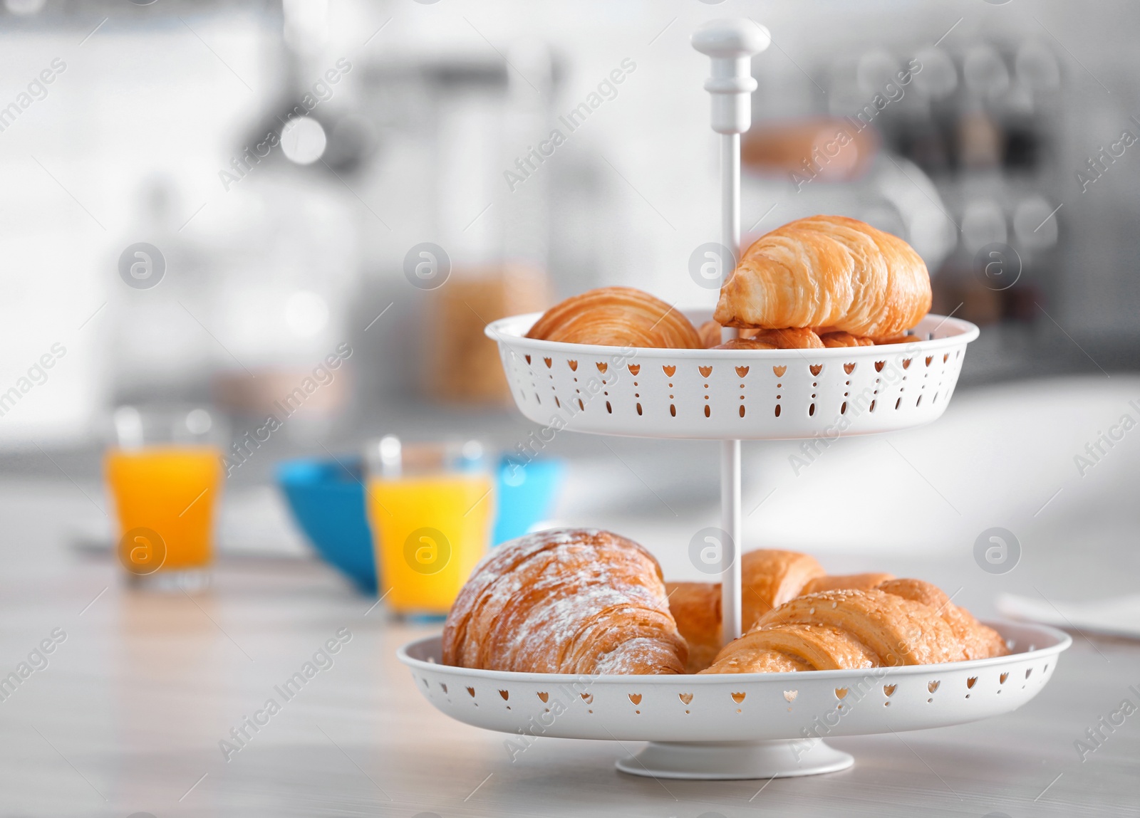 Photo of Dessert stand with tasty croissants on table