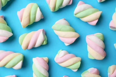 Photo of Delicious colorful marshmallows on light blue background, flat lay