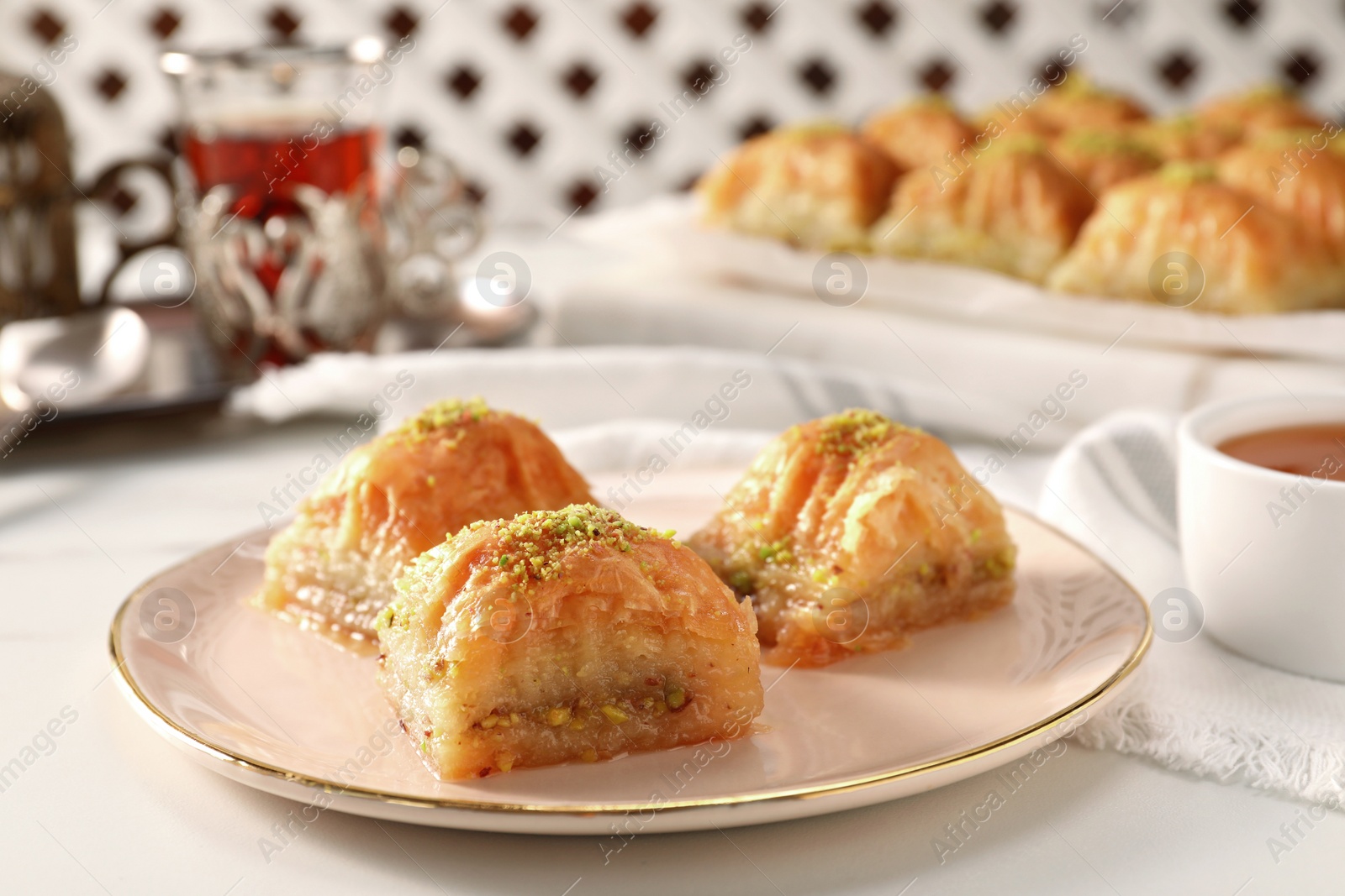 Photo of Delicious sweet baklava with pistachios on white table, closeup