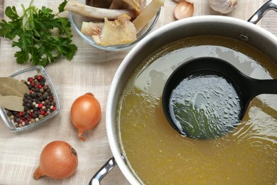 Delicious homemade bone broth and ingredients on table, flat lay