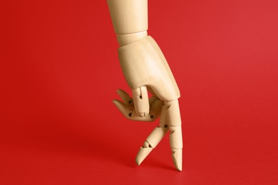 Wooden hand model on red background. Mannequin part