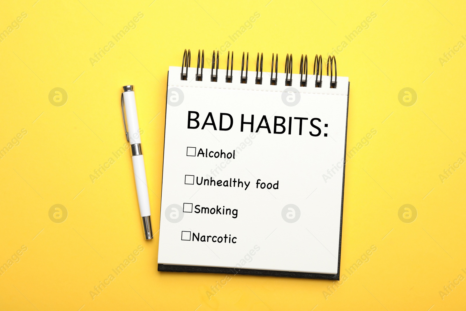 Image of Notebook with list of bad habits and pen on yellow background, top view. Change your lifestyle