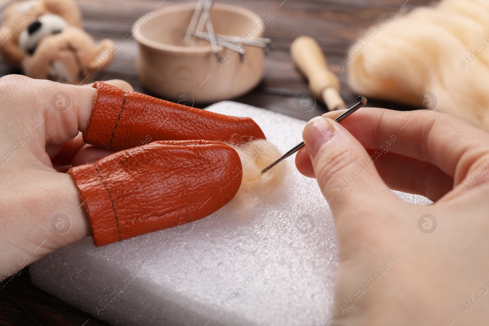 Photo of Woman felting from wool at table, closeup